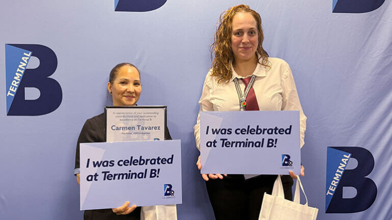 B-Celebrated winners: Two Terminal B employees pose for a photo holding certificates and signs