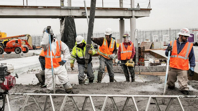 Workers pour concrete during the construction of Terminal B